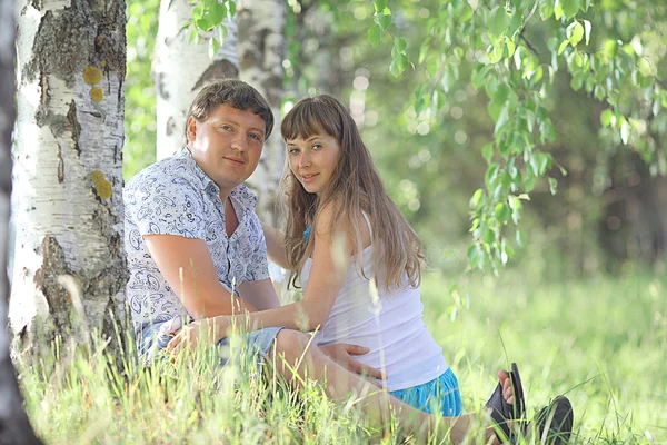 Mann und schwangere Frau liegen im Gras — Stockfoto