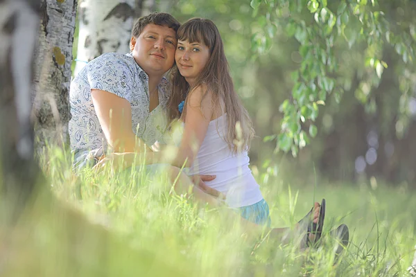 Homme et femme enceinte couchés sur l'herbe — Photo