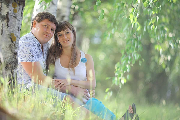 Мужчина и беременная женщина лежат на траве — стоковое фото