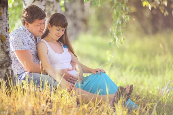 Hombre y una mujer embarazada tirado en el pasto — Zdjęcie stockowe