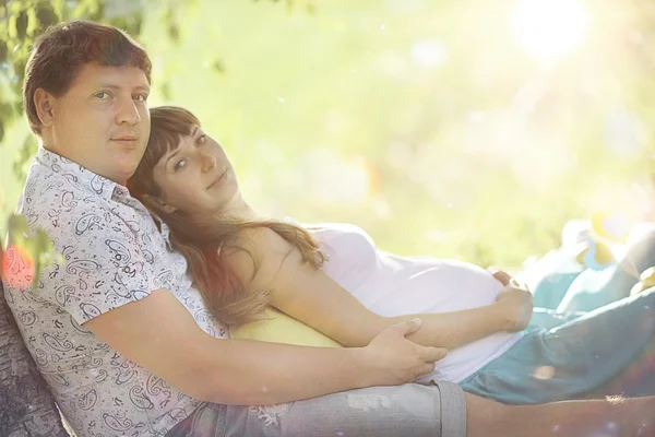 남자와 임신한 여자는 잔디에 누워 — 스톡 사진