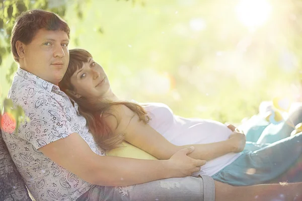 Homme et femme enceinte couchés sur l'herbe — Photo