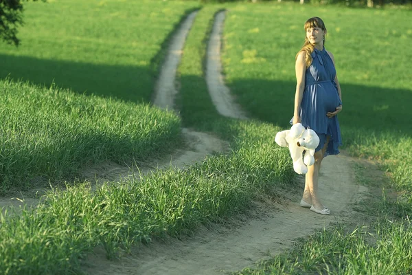 Girl walking along the road in a field — Stock Photo, Image