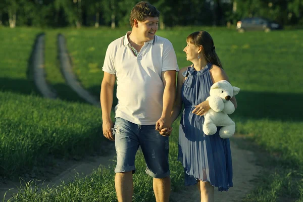 Man en een zwangere vrouw op het gebied — Stockfoto