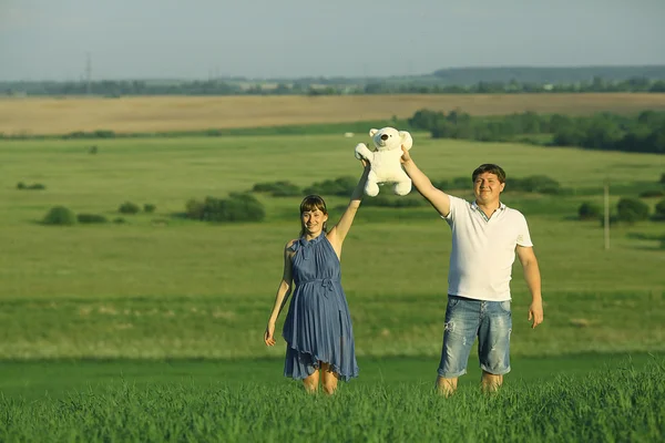 Man and a pregnant woman in field — Stock Photo, Image