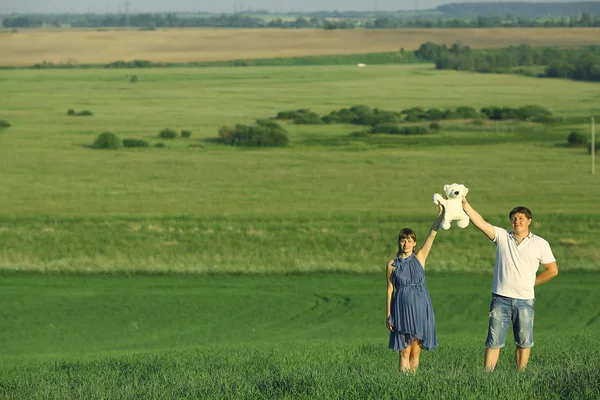 Man and a pregnant woman in field — Stock Photo, Image