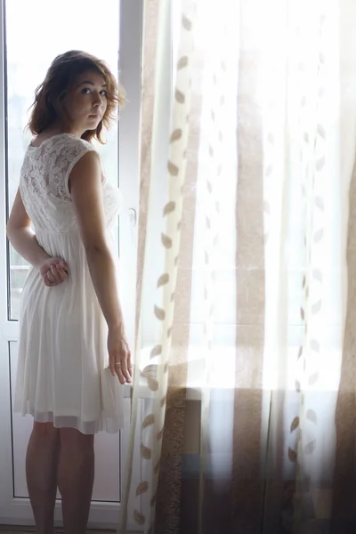 Girl standing at the window — Stock Photo, Image