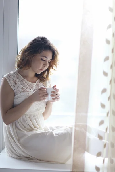 Girl sitting on the windowsill — Stock Photo, Image