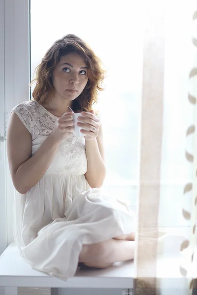 Girl sitting on the windowsill — Stock Photo, Image