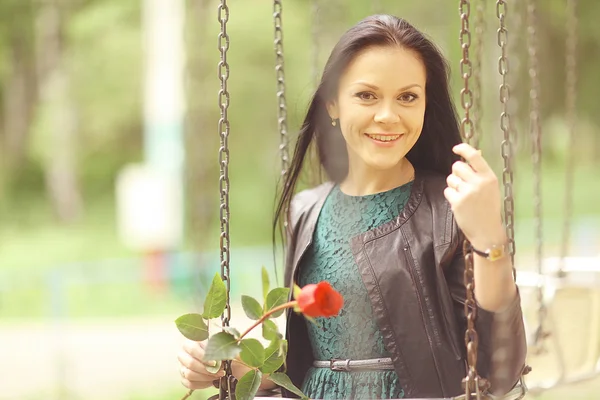 Ragazza con fiore su altalena — Foto Stock