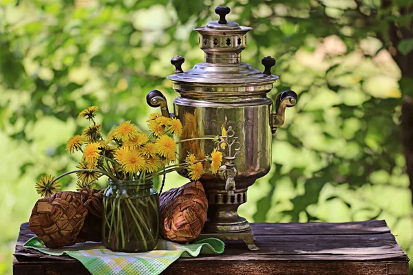 Samovar a pampelišky květiny — Stock fotografie