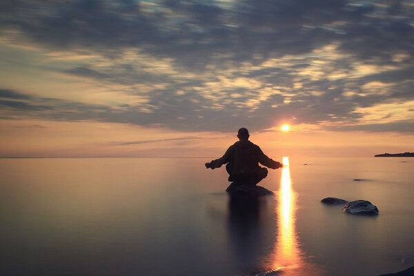 Man meditates on the lake