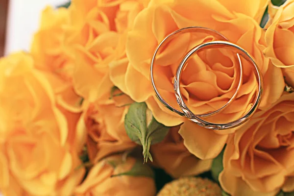Huwelijksringen met roze bloemen — Stockfoto