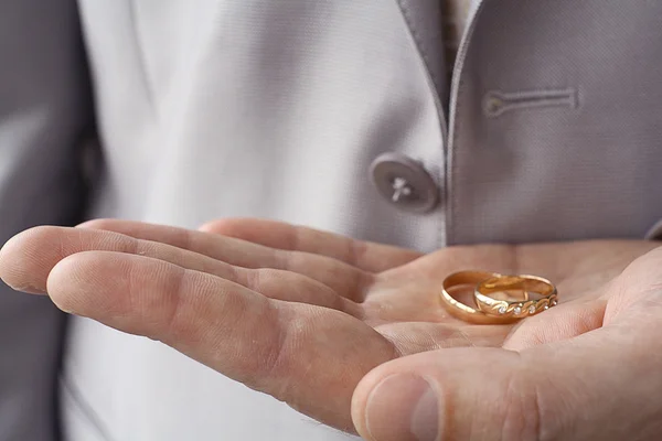 Wedding rings on the palm of the groom — Stock Photo, Image