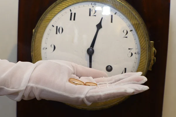 Clock and wedding rings on hand — Stock Photo, Image