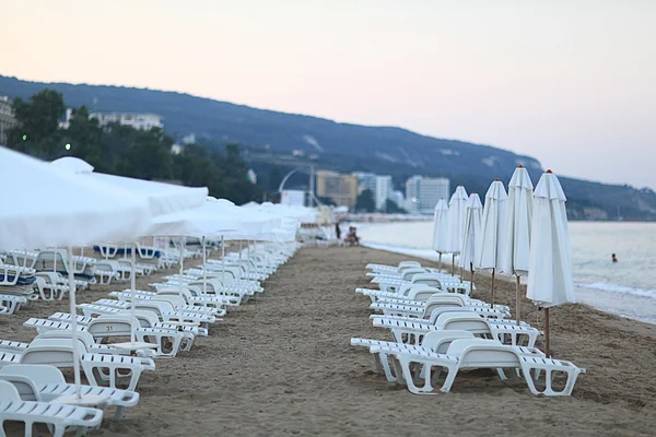 Parasols en ligbedden op het strand — Stockfoto