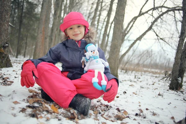 Liten flicka med snögubbe — Stockfoto