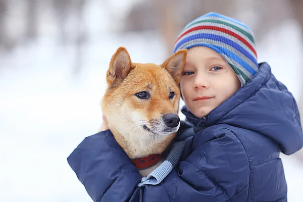 Liten pojke och hund på vintern — Stockfoto