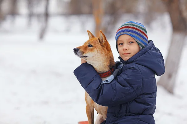 Liten pojke och hund på vintern — Stockfoto