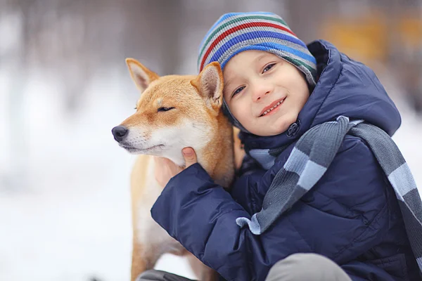 Liten pojke och hund på vintern — Stockfoto