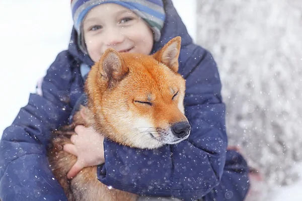 Liten pojke och hund på vintern — Stockfoto