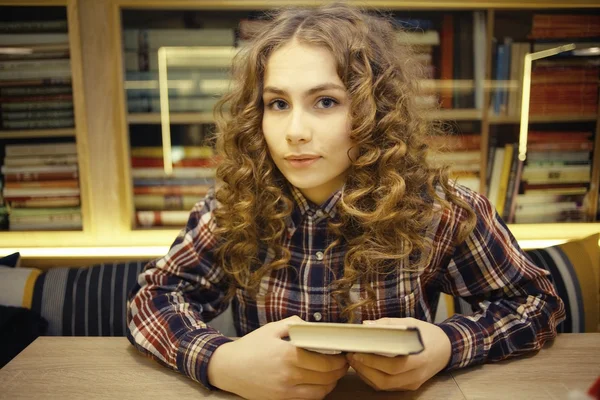 Молодая девушка в библиотеке — стоковое фото
