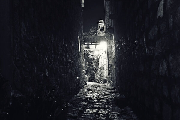 Night narrow street in old european town with stone walls of buildings