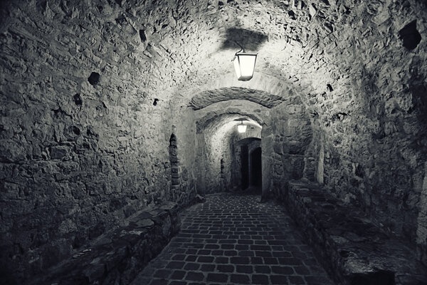Old stone walls tunnel, passage fortress interior with night light