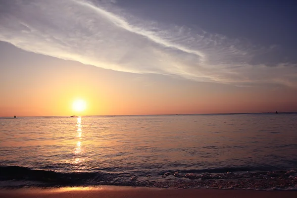 Surfen op zonsondergang strand — Stockfoto