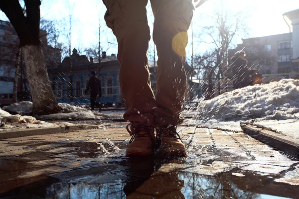 Man klädd i stövlar hoppa i en vattenpöl — Stockfoto