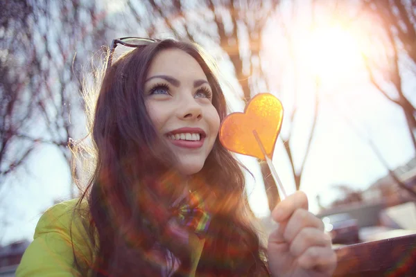 Girl holding heart shaped candy Stock Picture