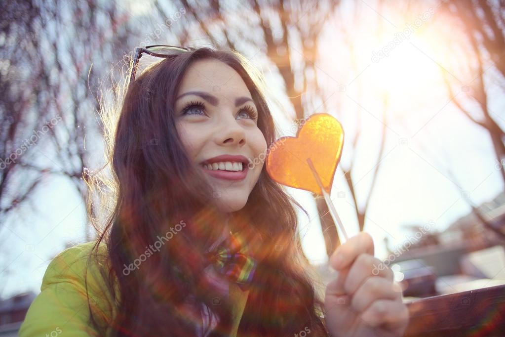 girl holding heart shaped candy