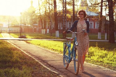 Girl with bike at sunset clipart