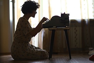 woman s typing on an old fashion type-writer clipart