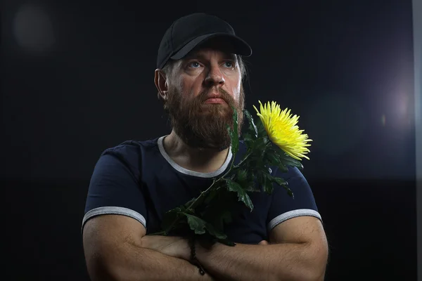 Skäggig brutala man med en blomma — Stockfoto