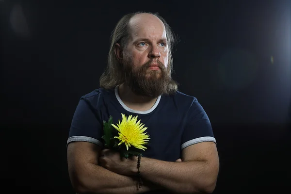 Vousatý brutální muž s květinou — Stock fotografie