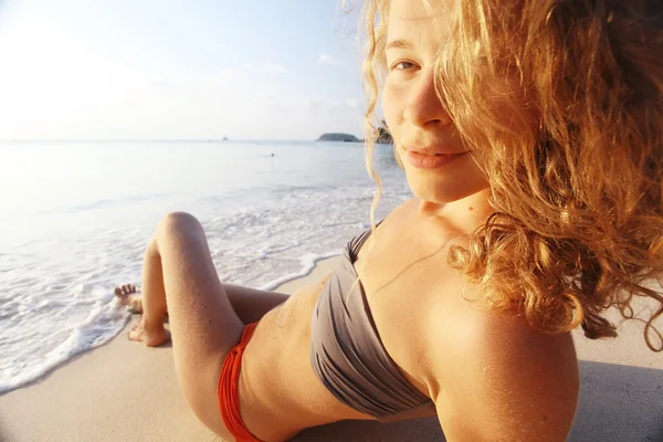 Menina tomando banho de sol na praia — Fotografia de Stock