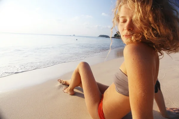 Menina tomando banho de sol na praia — Fotografia de Stock