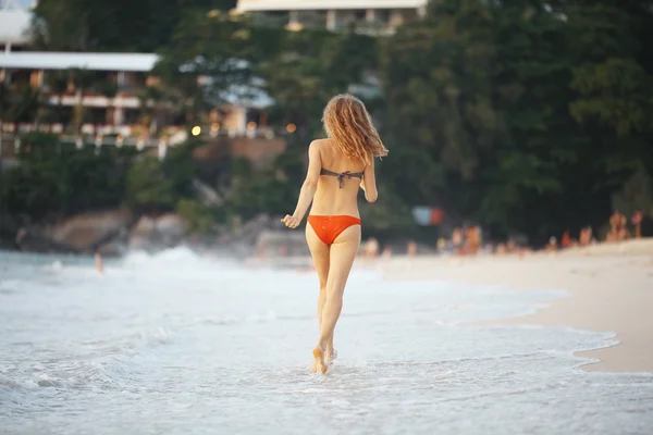 Menina corre ao longo da praia — Fotografia de Stock