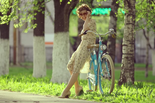 Menina com uma bicicleta na rua — Fotografia de Stock