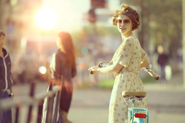 Flicka med en cykel på gatan — Stockfoto