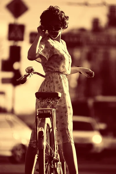 Menina com uma bicicleta na rua — Fotografia de Stock