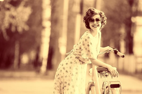 Chica con una bicicleta en la calle — Foto de Stock