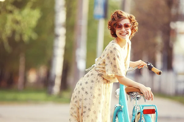 Chica con una bicicleta en la calle — Foto de Stock