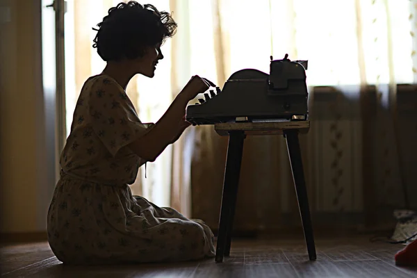 Woman 's typing on an old fashion type-writer — стоковое фото