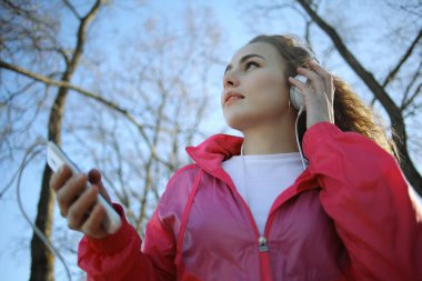 Kız parkta yürüyüş ve müzik dinlemek