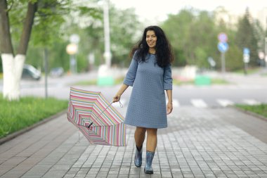 şemsiye ile yürüyen genç bir kadın