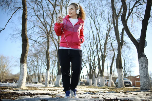 Girl walking in the park and listening music — Stock Photo, Image