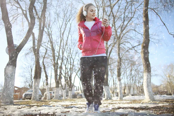 Fille marche dans le parc et écouter de la musique — Photo