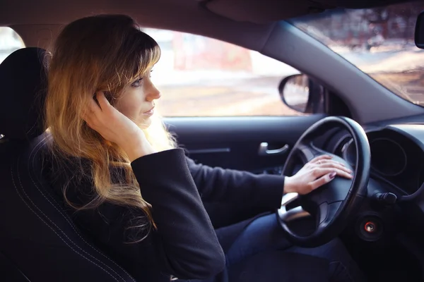 Meisje besturen van de auto en praten van de telefoon — Stockfoto